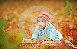 Baby girl with Down syndrome is resting in autumn forest