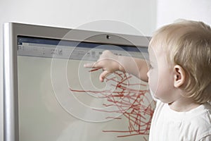 Baby Girl Drawing On Computer Screen At Home