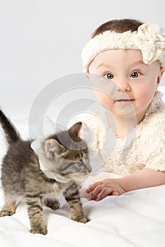 Baby girl dressed in white fur plays with little