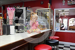 Baby Girl Eating Candy at Ice Cream Shoppe photo