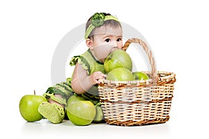 Baby girl eating green apples from basket