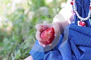 Baby girl is eating strawberrt