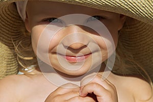 Baby girl face sunlit under hat