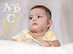 Baby girl gazing at letters and dazzle photo