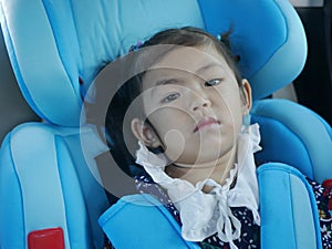 A baby girl getting bored sitting in a car seat and waiting to arrive at a destination