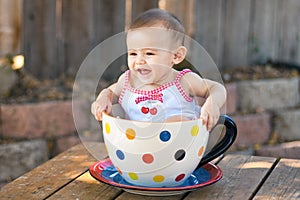 Baby girl in giant teacup