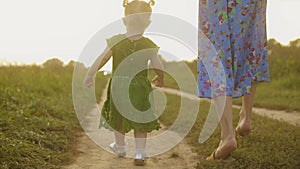 Dieťa v zelený šaty jej mamička chôdze pozdĺž vidiecky cesta spoločne na slnečný leto 