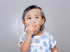 Baby girl with hand cover her mouth