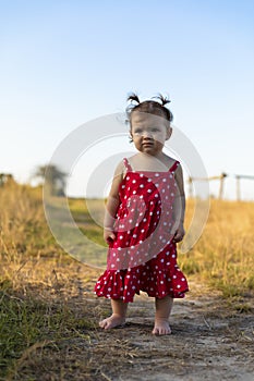 Baby girl have fun in the meadow, running barefoot on the grass