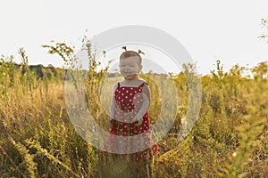 Baby girl have fun in the meadow, running barefoot on the grass