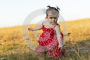 Baby girl have fun in the meadow, running barefoot on the grass