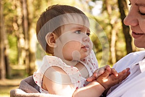 baby girl in her mother's arms clapping her hands