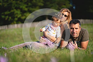 Baby Girl with her Parents Sitting in the Field
