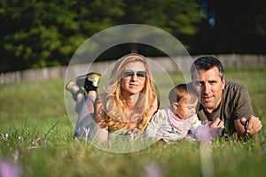 Baby Girl with her Parents Sitting in the Field