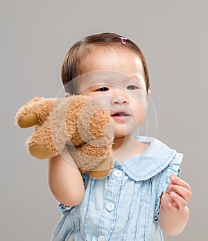 Baby girl holding her bear doll