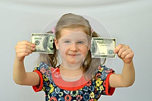 Baby girl holds in hands a torn banknote ,dollar ,banking crisis.