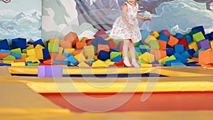 Baby girl jumping on a trampoline and playing on a children`s playground. Games for children.