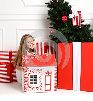 Baby Girl Kid playing with christmas red house in play room at home or kindergarten with little dolls toys