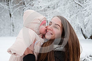 Baby girl kisses mom on the cheek