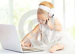 Baby girl at laptop computer, mobile phone