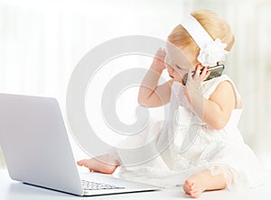 Baby girl at laptop computer, mobile phone