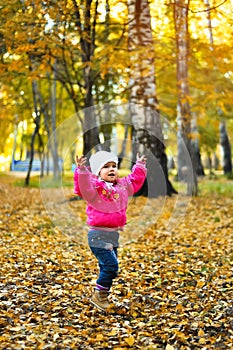 Baby girl laughing and playing in the autumn
