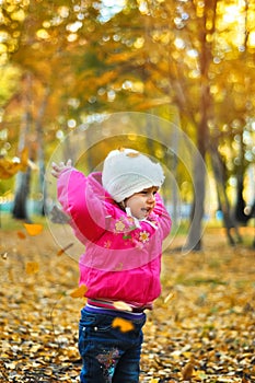 Baby girl laughing and playing in the autumn