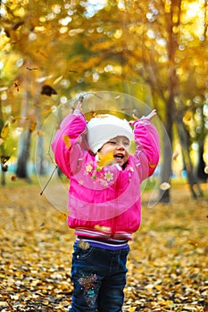 Baby girl laughing and playing in the autumn