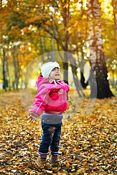 Baby girl laughing and playing in the autumn