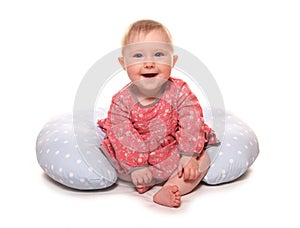 Baby girl learning to sit using a pillow