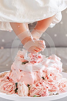 baby girl legs feet stepping in cake during her birthday celebration