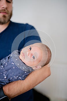 Baby Girl is Looking Concerned in Her Blue Onesie While dad looks on