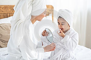 Baby girl looking at mirror, applying lipstick