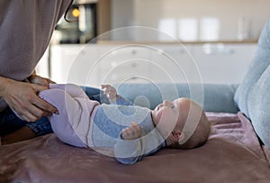 Baby girl lying on back and smiling at mom