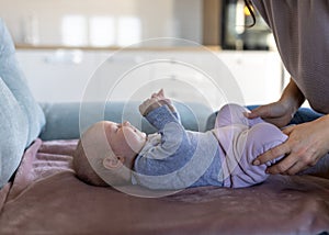 Baby girl lying on back and smiling at mom