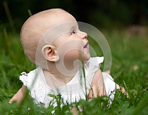 Baby girl lying on grass