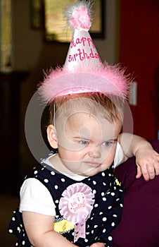 Baby girl making a funny face at her first birthday party