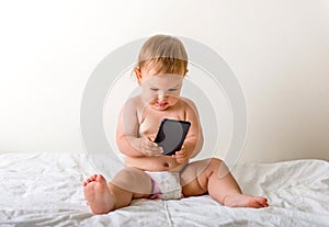 Baby girl with mobile phone near her ear, calling someone, copy space, gen z development