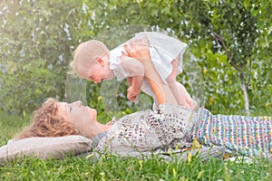 Baby girl on mother`s hands. Smiling toddler with mother. Life beginning concept. Business lady with a child.