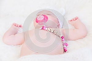 Baby Girl Named Leila Sleeping and Wearing a Wooden Pacifier Chain photo