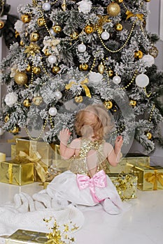 Baby girl near luxury decorated christmas tree