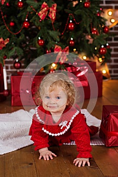 Baby girl near luxury red christmas tree