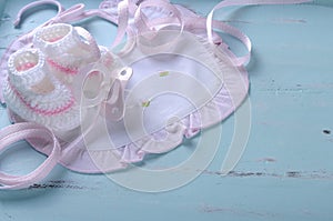 Baby girl nursery bib and booties on vintage blue background