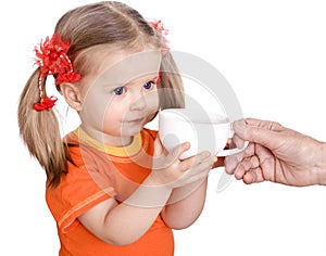 Baby girl in orange eat pear.