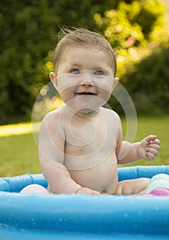 Baby girl in a paddling pool