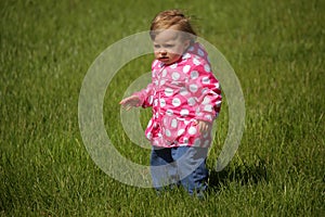 Baby girl in the park on a windy day