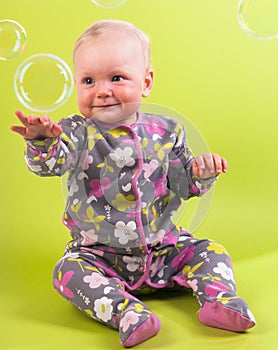 Baby girl with pink capitium and soap bubble