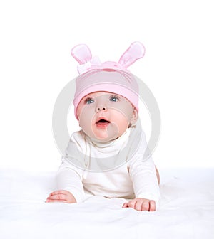 Baby girl in a pink hat with rabbit ears isolated on white