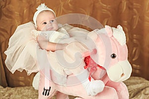 Baby girl on a pink poney photo