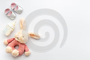 Baby girl pink shoes with milk and toy. Newborn set background